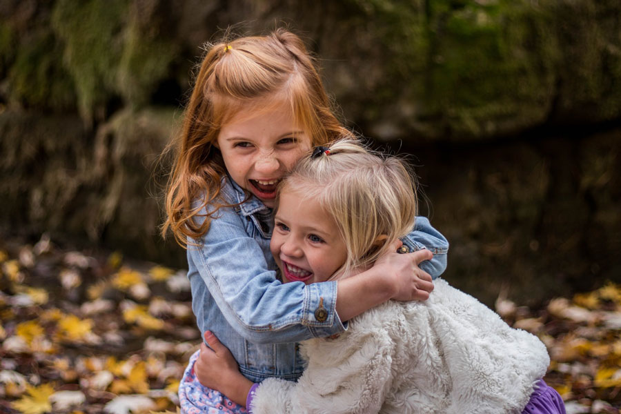 Two young girls hugging and giggling